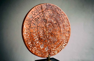 Spiraltext auf dem Diskos (Ton, 16 cm Ø und 2 cm Dicke) aus dem Palastarchiv von Phaistos mit 242 spiralförmig angeordneten Bildzeichen auf beiden Seiten. Dieses von Pernier auf etwa 1700 v. Chr. datierte Schriftdokument ist herstellungstechnisch betrachtet, vielleicht das älteste Druckwerk der Kulturgeschichte, denn die bis heute nicht entzifferten Hieroglyphenzeichen wurden mit Stempeln in den weichen Ton gepresst, bevor der Diskos hart gebrannt wurde. Gefunden wurde das Artefakt 1908 von Arbeitern des italienischen Archäologen Luigi Pernier (1874–1937) auf Kreta. Das Original befindet sich im Archäologischen Museum in Iraklio auf Kreta (Heraklion, Griechenland). Foto: Wolfgang Beinert, Berlin. Quelle: Modell (beschädigt) aus der Sammlung Beinert.